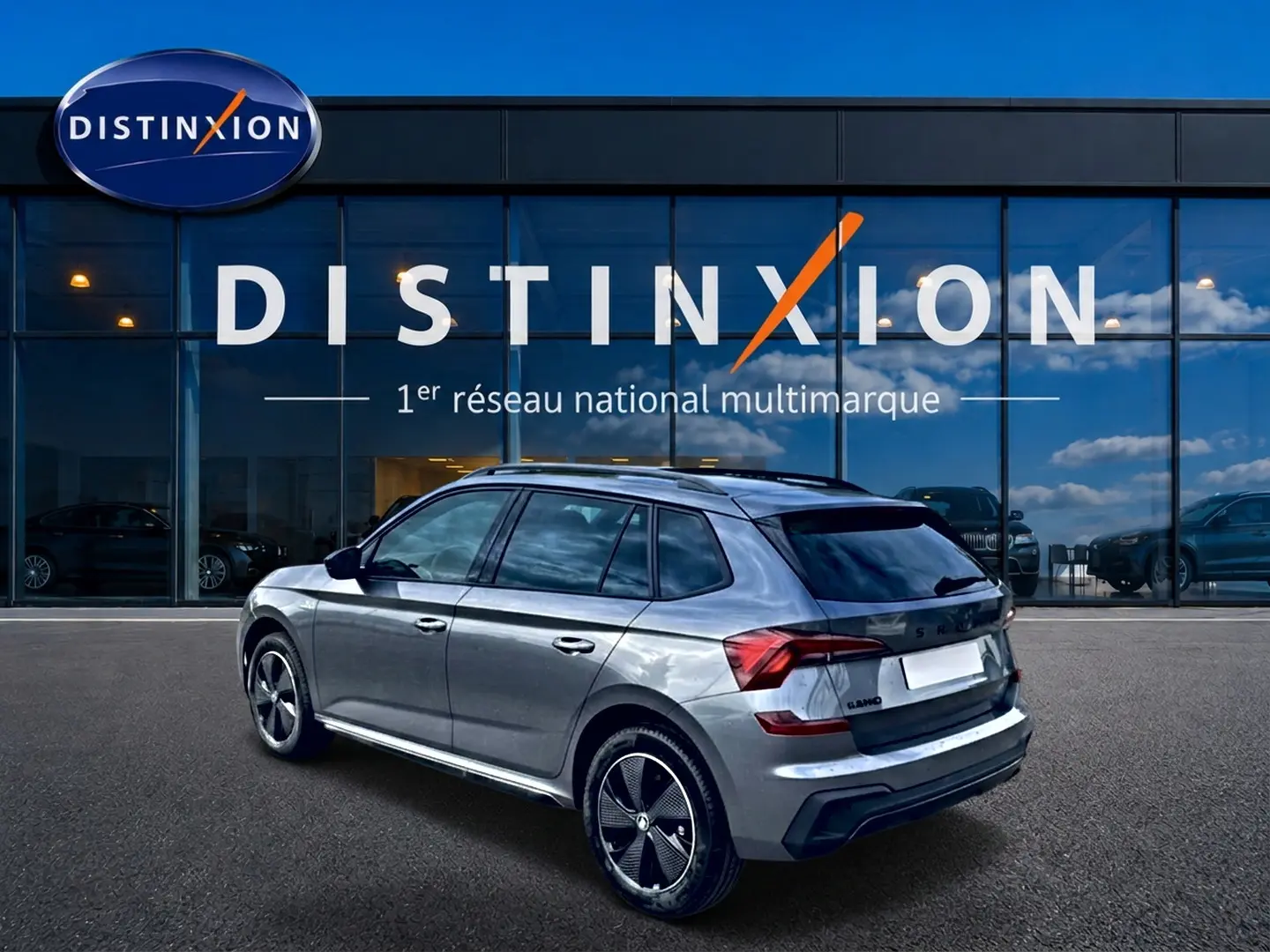 Vue 3/4 arrière droite du Skoda Kamiq gris graphite avec jantes alu et toit panoramique en verre.