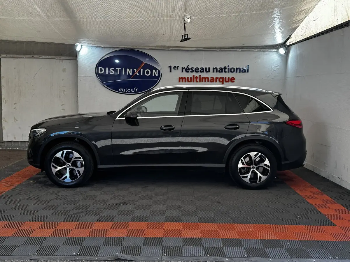 Vue de profil côté gauche d'un Mercedes GLC 300 E Business Line 4MATIC gris foncé dans un showroom.