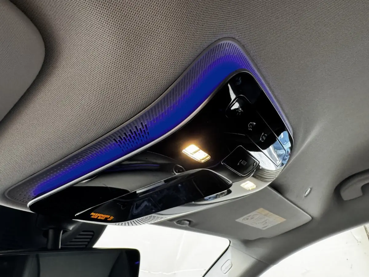 Plafonnier intérieur noir brillant avec éclairage LED et ambiance lumineuse bleue dans un Mercedes GLC gris foncé 2023.