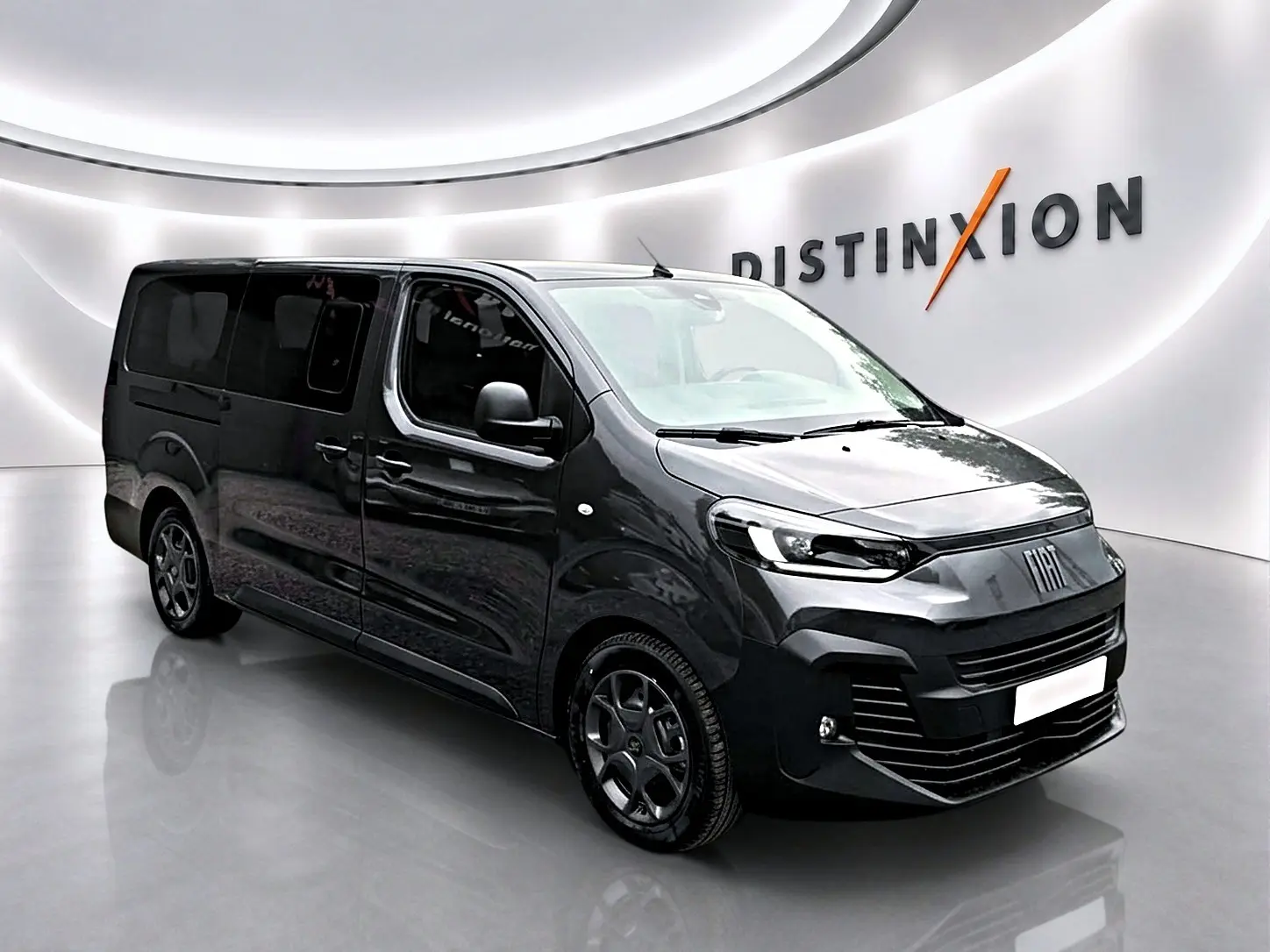 Fiat Scudo Combi gris titane en 3/4 avant droit, porte latérale coulissante visible, ambiance showroom lumineuse.
