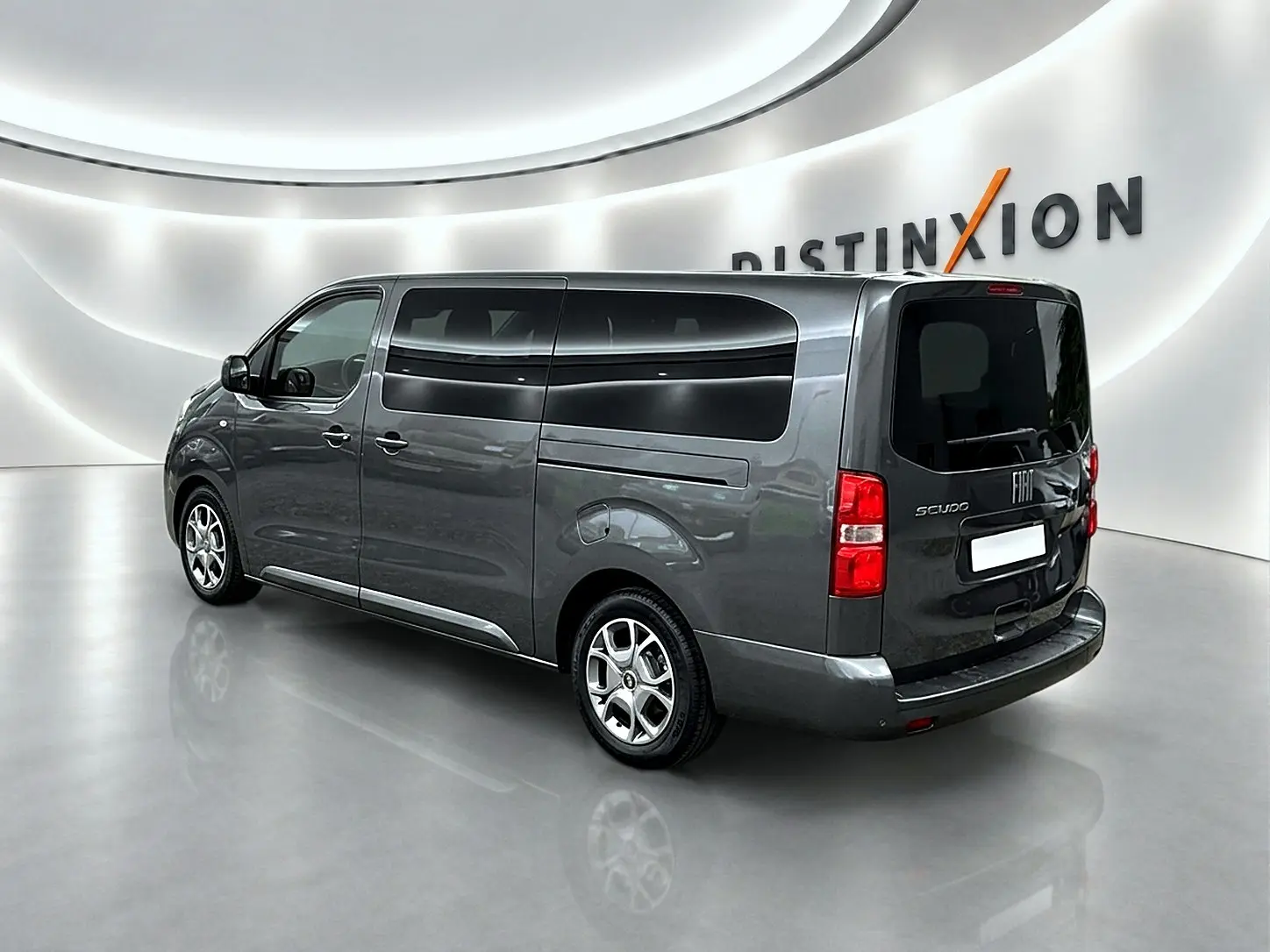 Vue 3/4 arrière droite d'un FIAT Scudo Combi gris titane avec porte latérale coulissante et vitres teintées.