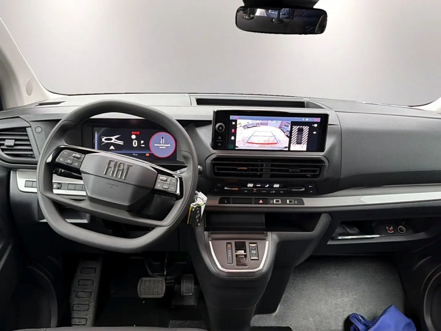 Vue intérieure avant du Fiat Scudo Combi 2026, tableau de bord gris avec écran tactile et volant multifonctions.