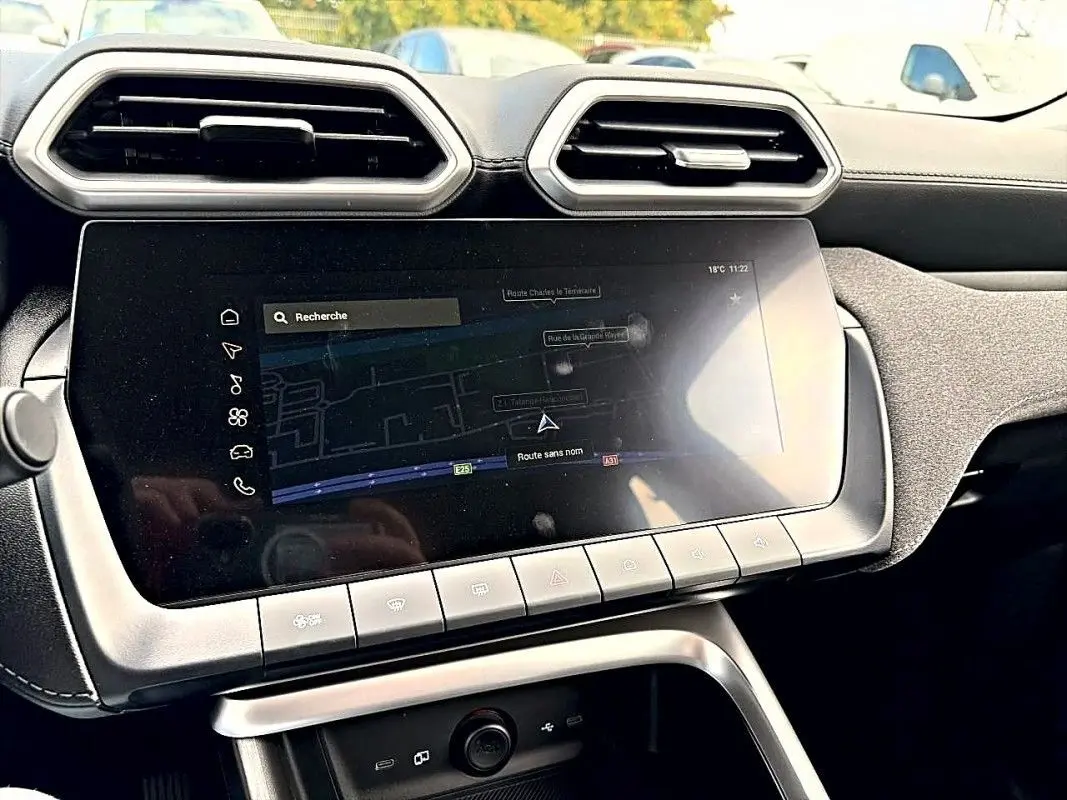 Vue rapprochée du volant noir perforé du MG ZS Hybrid 197 2026 avec tableau de bord numérique en arrière-plan flou.