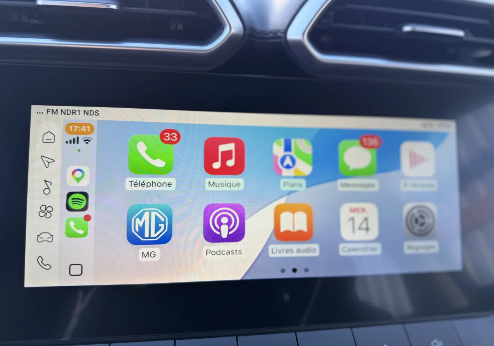 Écran tactile central du MG ZS Hybrid 2026 montrant l'interface Apple CarPlay avec plusieurs applications colorées.