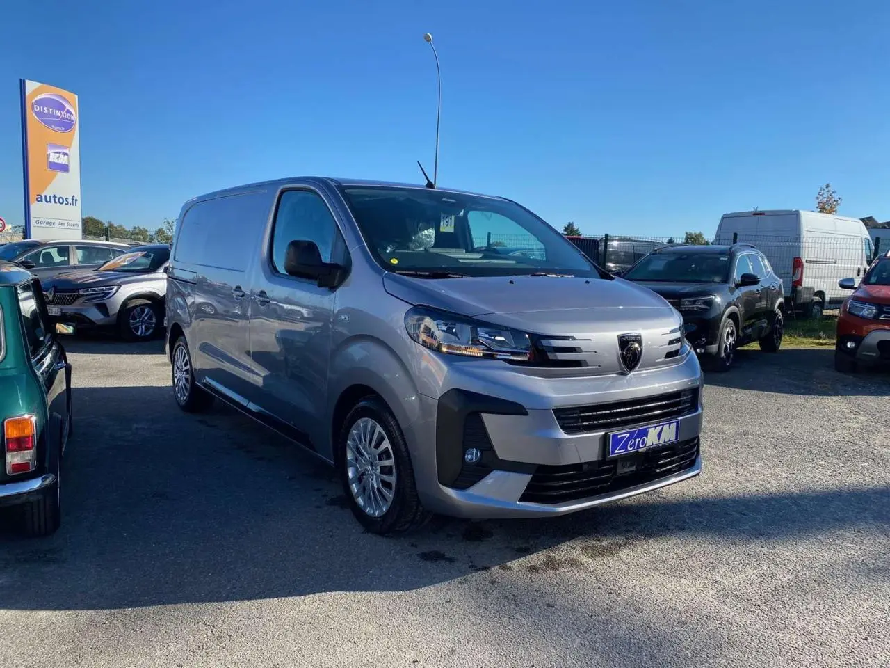 Vue 3/4 avant droite d'un Peugeot Expert Fourgon gris Artense garé en extérieur, avec calandre et phares modernes visibles.