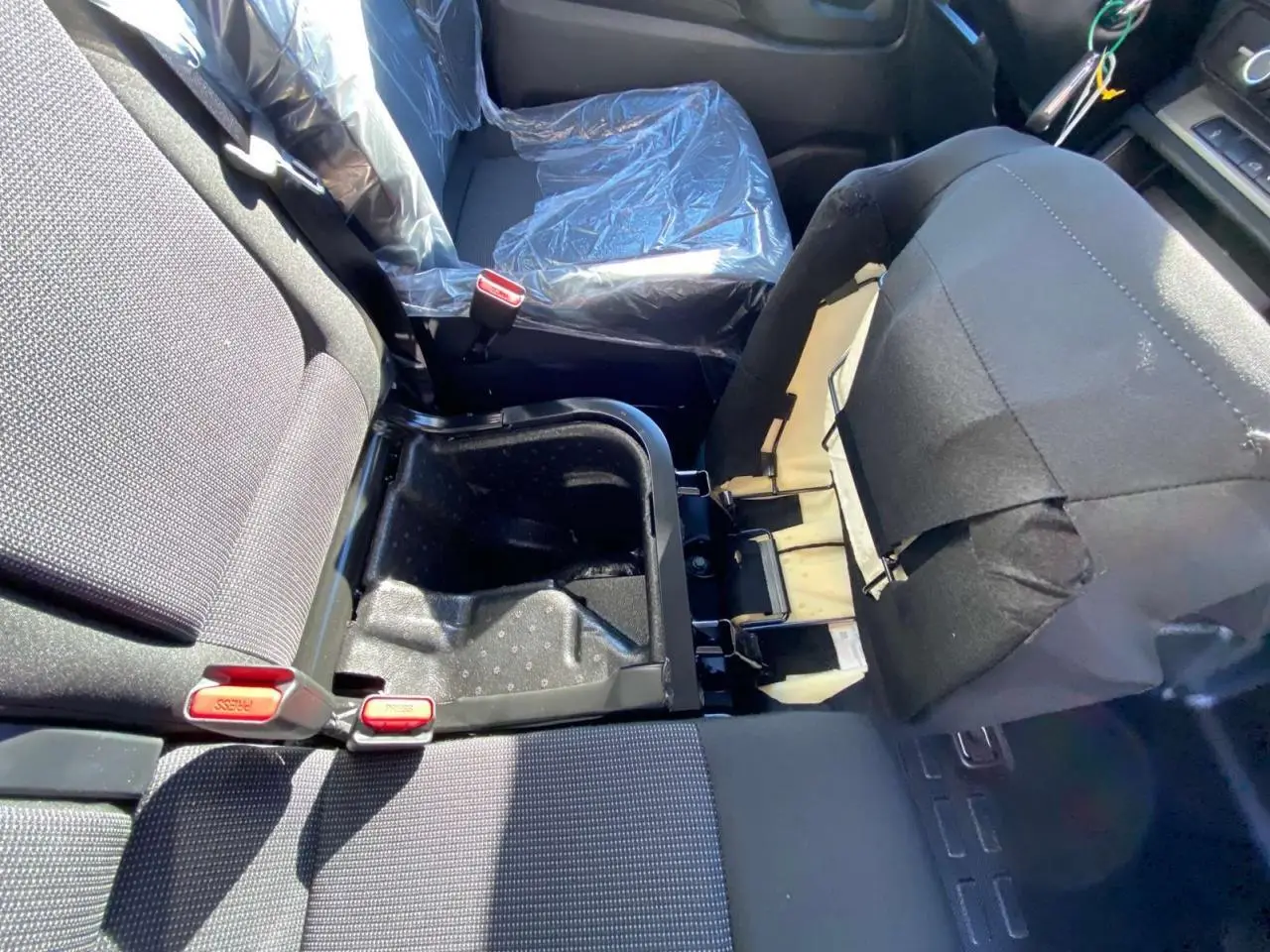 Vue intérieure du siège passager droit relevé du Peugeot Expert Fourgon gris, montrant le rangement sous assise ouvert.
