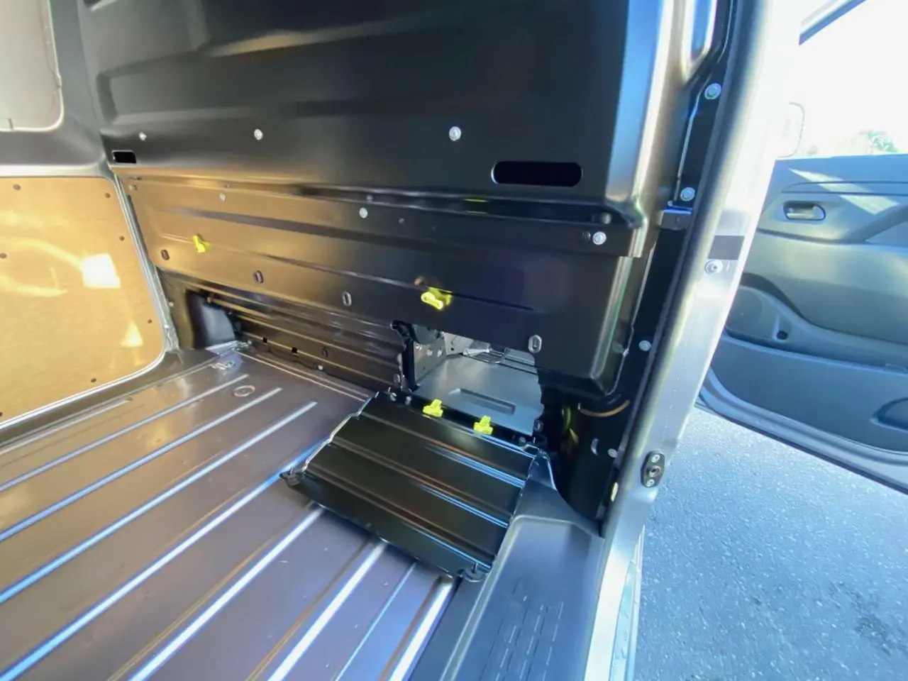 Vue intérieure de l'espace de chargement du Peugeot Expert Fourgon gris Artense, avec porte latérale ouverte et plancher métallique.