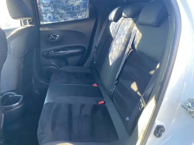 Vue latérale droite de l'intérieur arrière du Nissan Juke 2018, sièges en tissu noir avec ceintures de sécurité visibles.