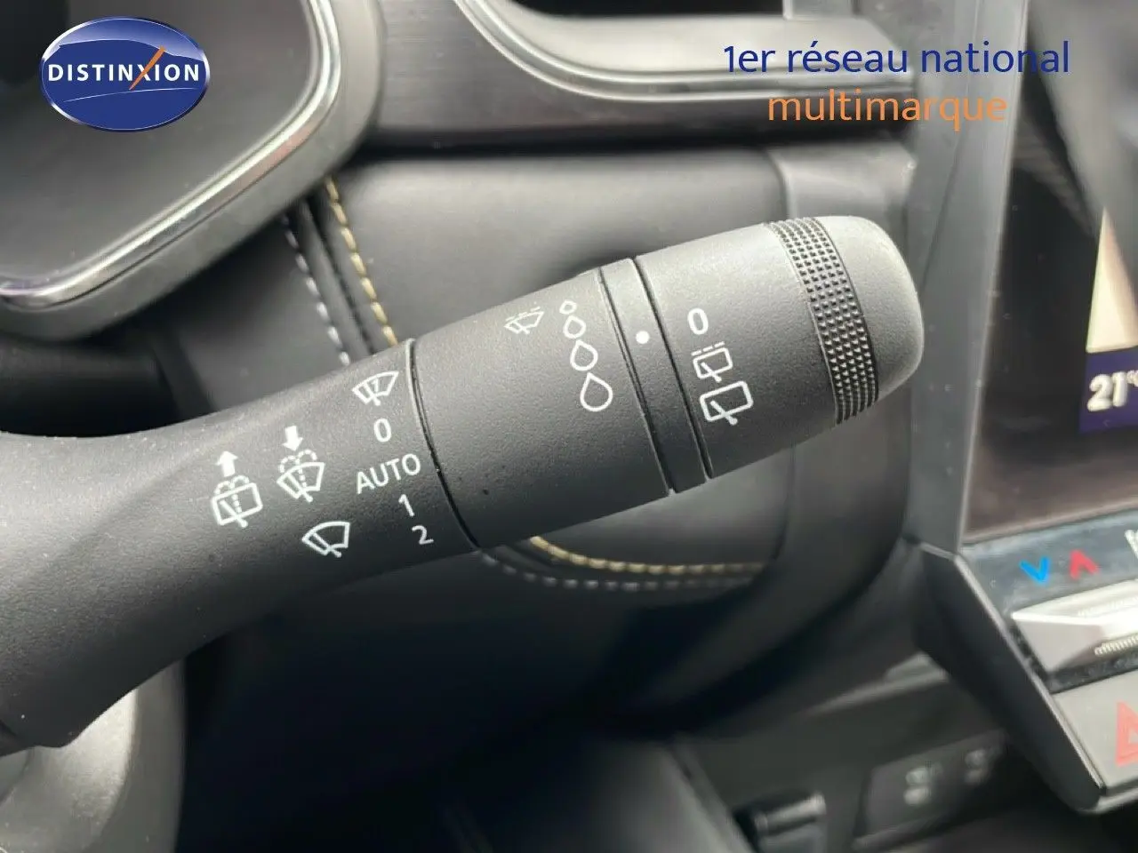 Gros plan sur la commande d’essuie-glace à gauche du volant dans l’habitacle noir du Renault Symbioz bleu Iron Metal.