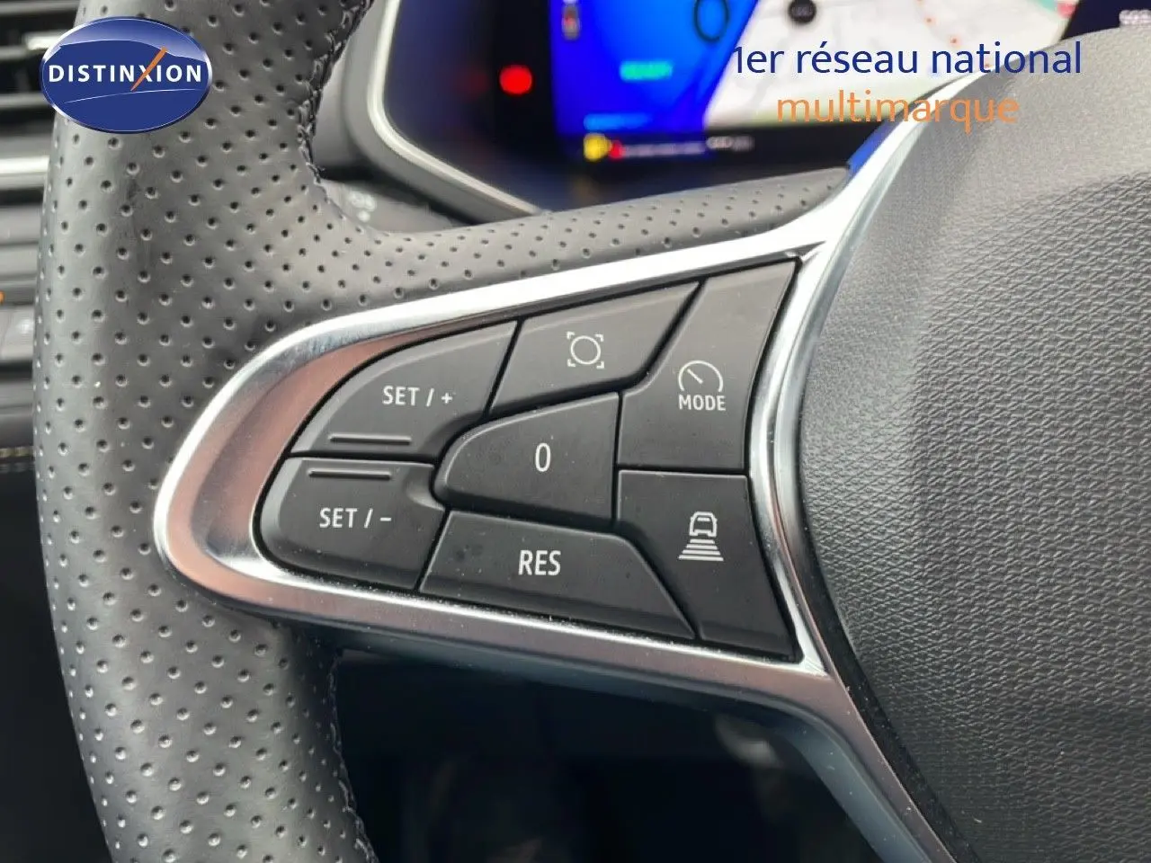 Gros plan sur les commandes de régulateur de vitesse au volant perforé d’un Renault Symbioz bleu Iron Metal.