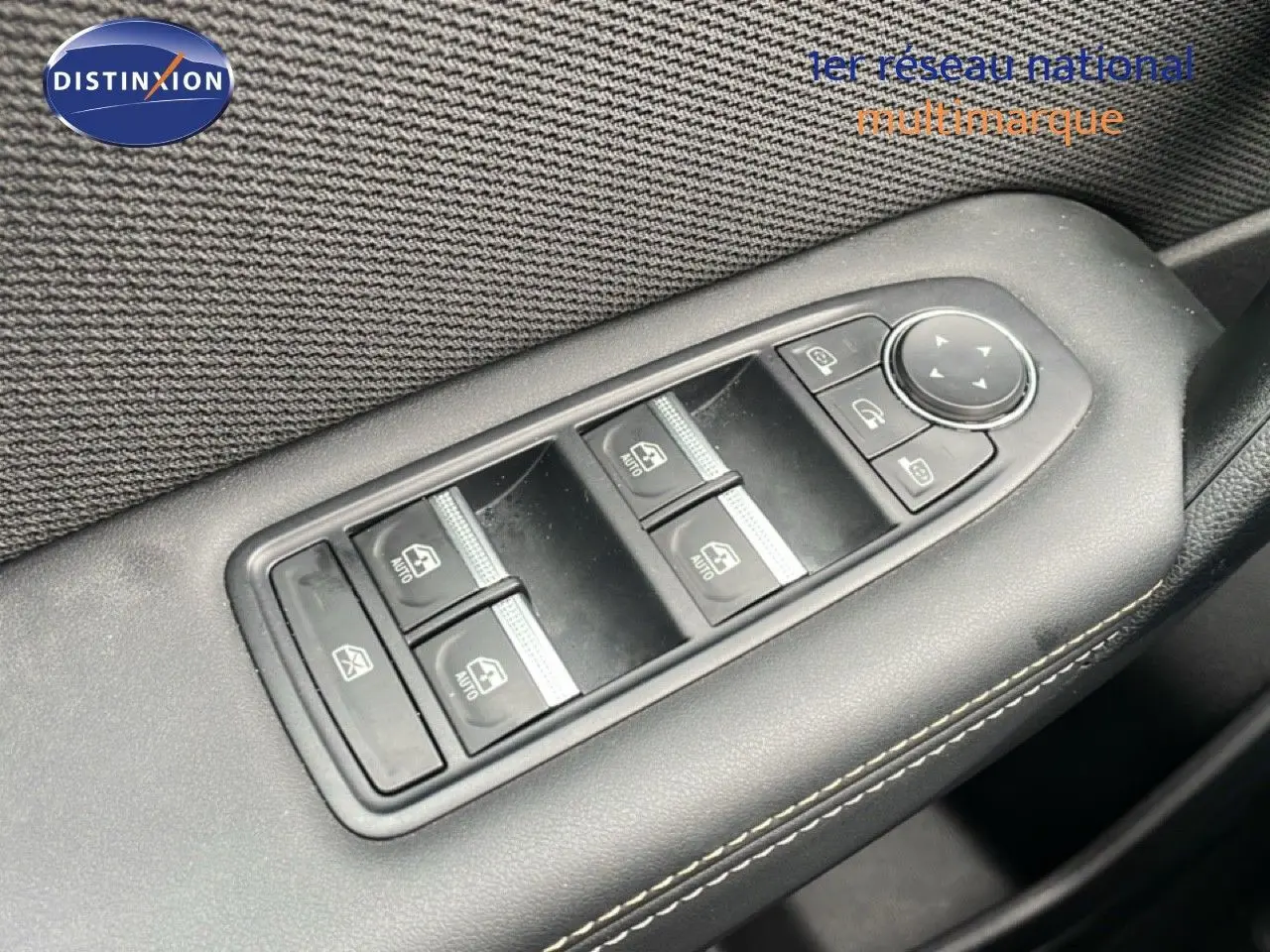 Gros plan sur les commandes de lève-vitres et rétroviseurs côté conducteur d'une Renault Symbioz bleu iron metal.