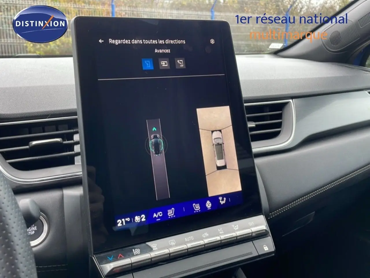 Vue intérieure du tableau de bord de la Renault Symbioz bleu iron metal, avec écran tactile central affichant la caméra 360° et la climatisation.