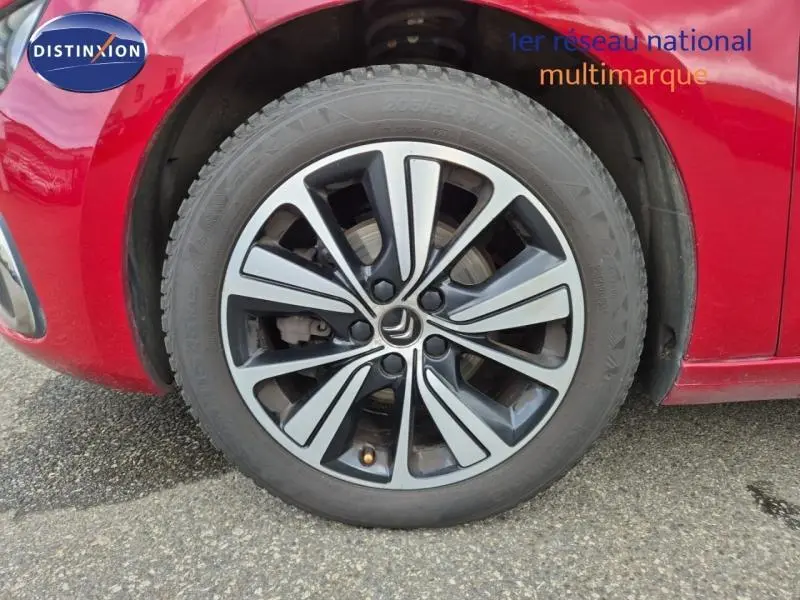 Gros plan sur la roue avant gauche avec jante alu bicolore du Citroën Grand C4 Spacetourer Rouge Rubi.