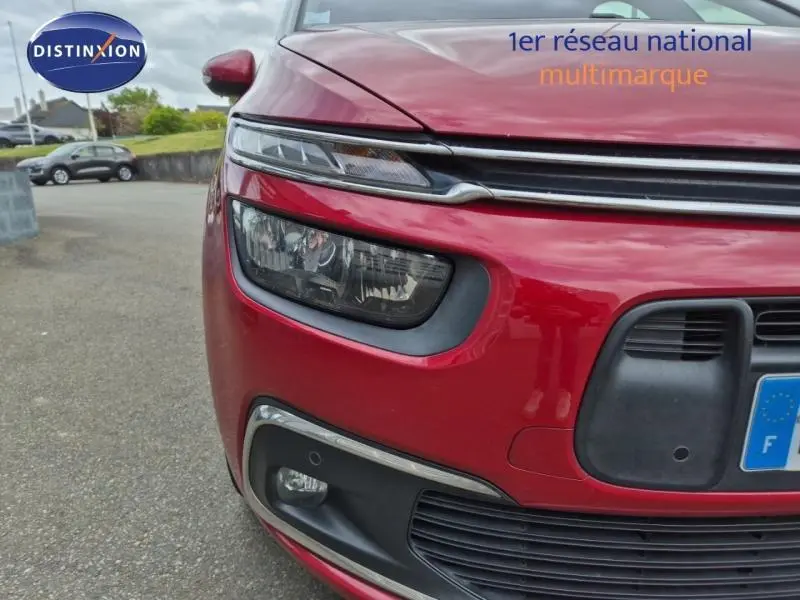 Gros plan sur l'avant gauche rouge Rubi du Citroën Grand C4 Spacetourer avec phares et calandre distinctifs.