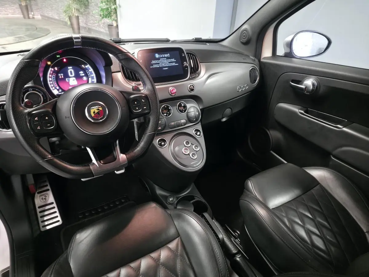 Intérieur noir cuir de l'Abarth 500 595C 2021 vu côté conducteur, avec volant sport et tableau de bord moderne.