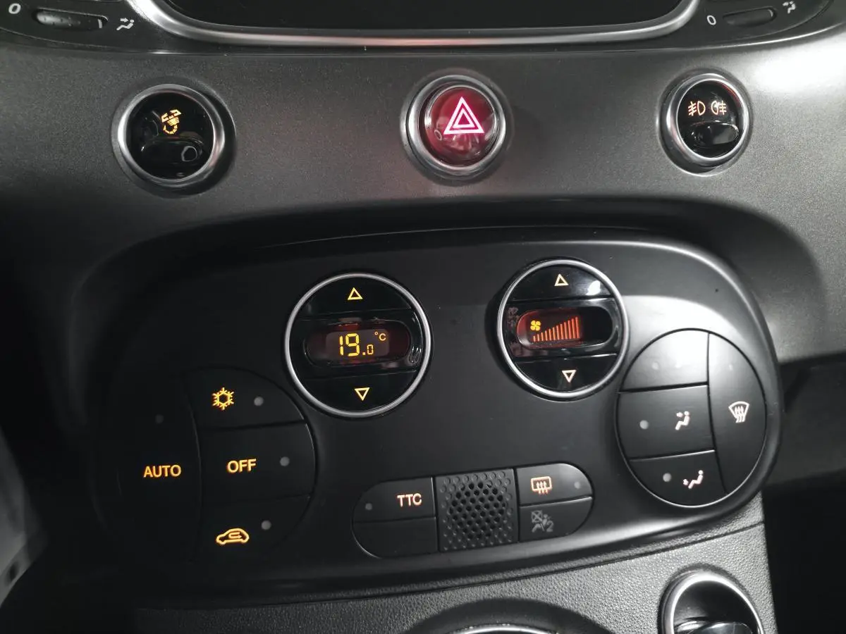Tableau de bord de l'Abarth 595C blanc, vue rapprochée sur les commandes de climatisation et boutons TTC.