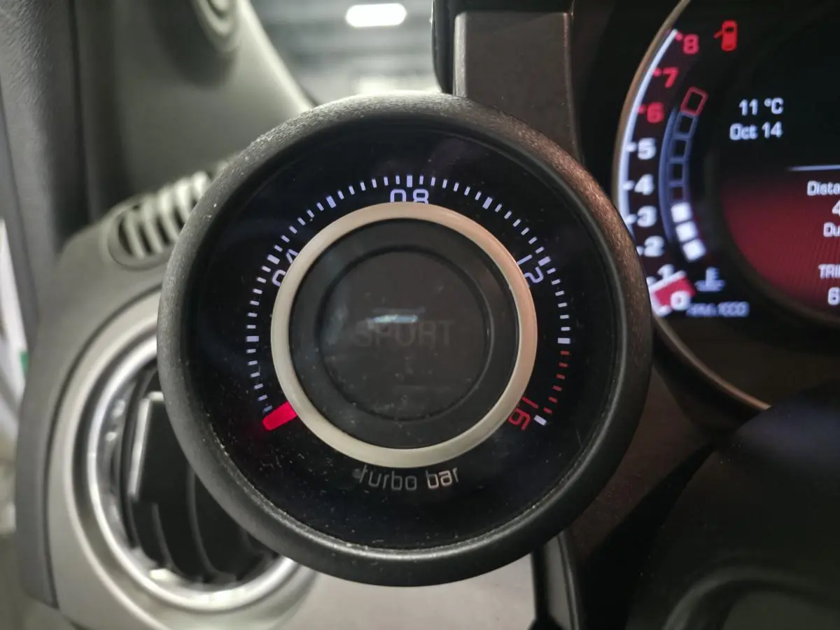 Gros plan sur le manomètre de pression turbo avec mode Sport, tableau de bord gris satiné de l'Abarth 595C blanc.
