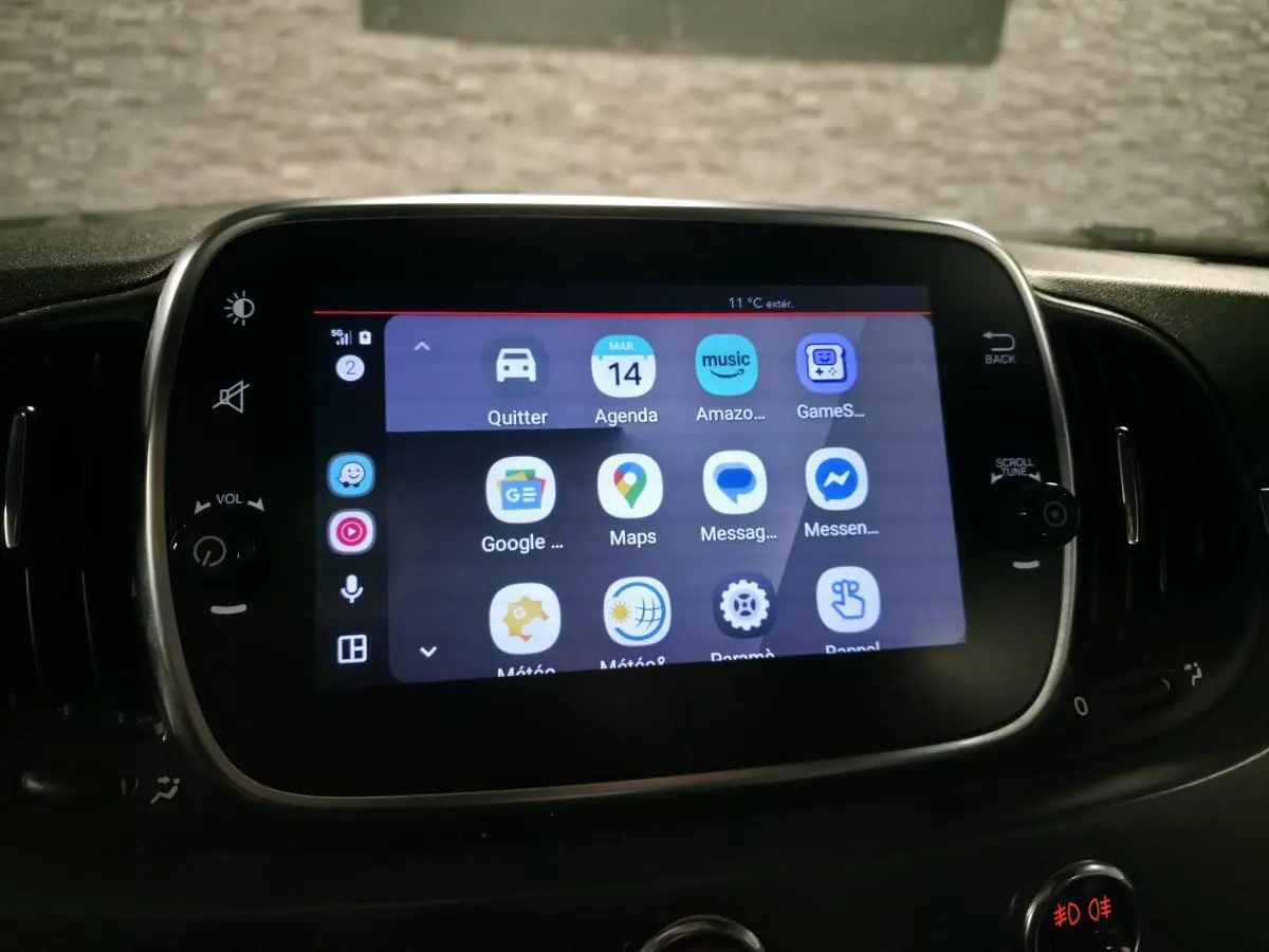 Écran tactile central de l'Abarth 595C blanc affichant des applications connectées, entouré de commandes noires.