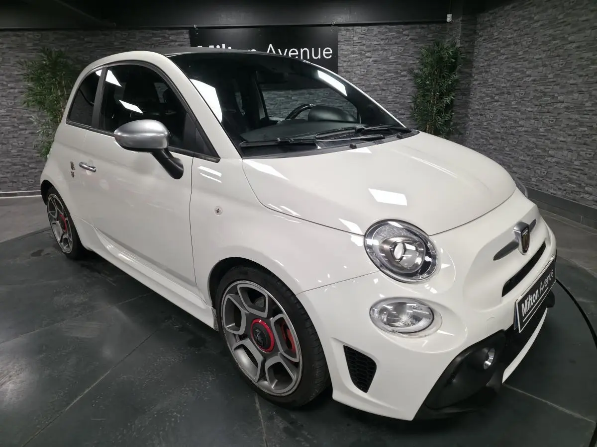 ABARTH 500 blanc en 3/4 avant droit, avec étriers de frein rouges et coques de rétroviseurs chrome satiné.