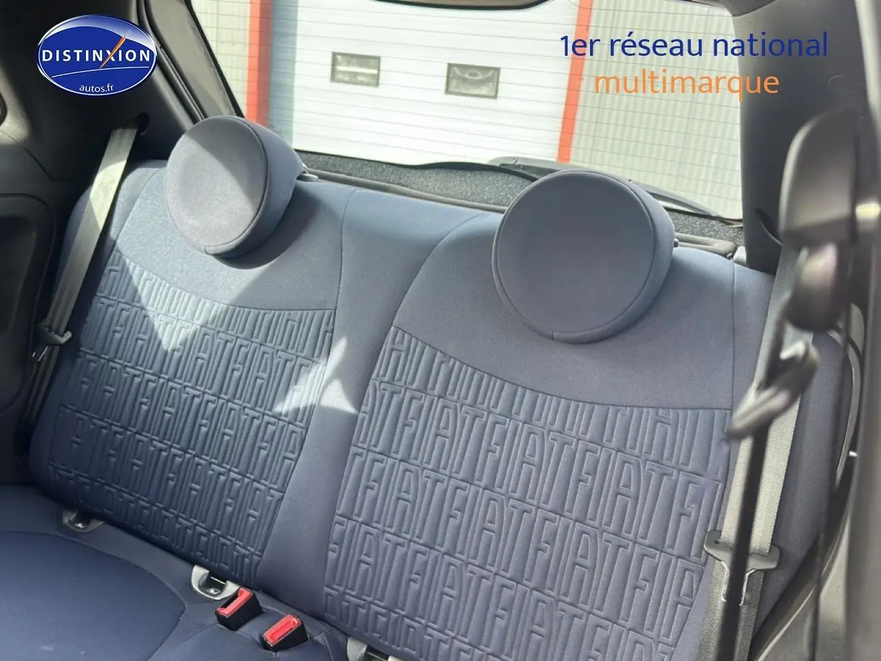 Vue intérieure sur la banquette arrière grise de la Fiat 500 avec appuie-têtes ronds et ceinture de sécurité visible.