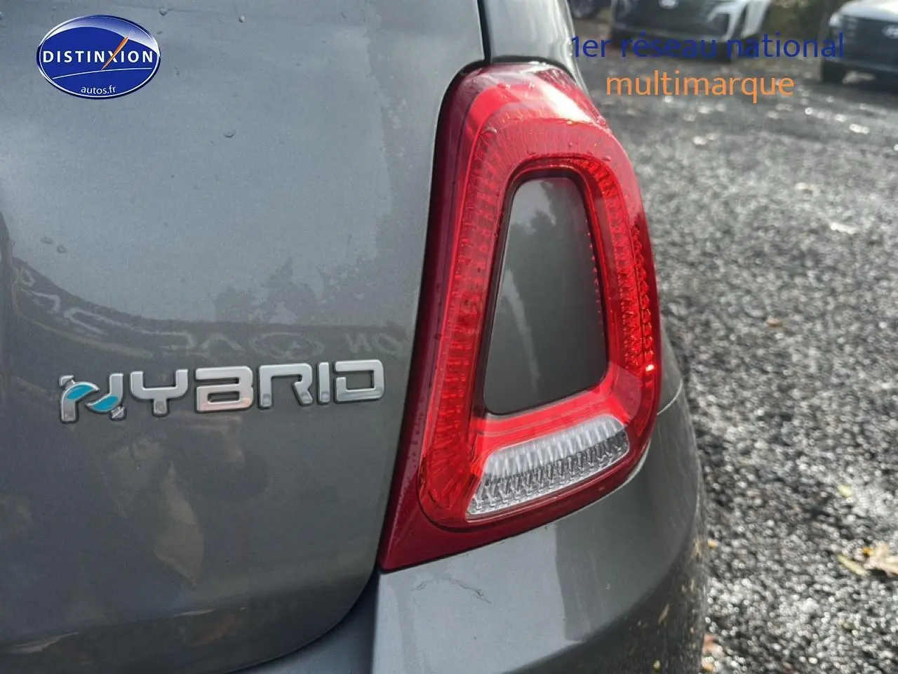 Gros plan sur le feu arrière droit gris d'une FIAT 500 avec le badge Hybrid visible sur le coffre.