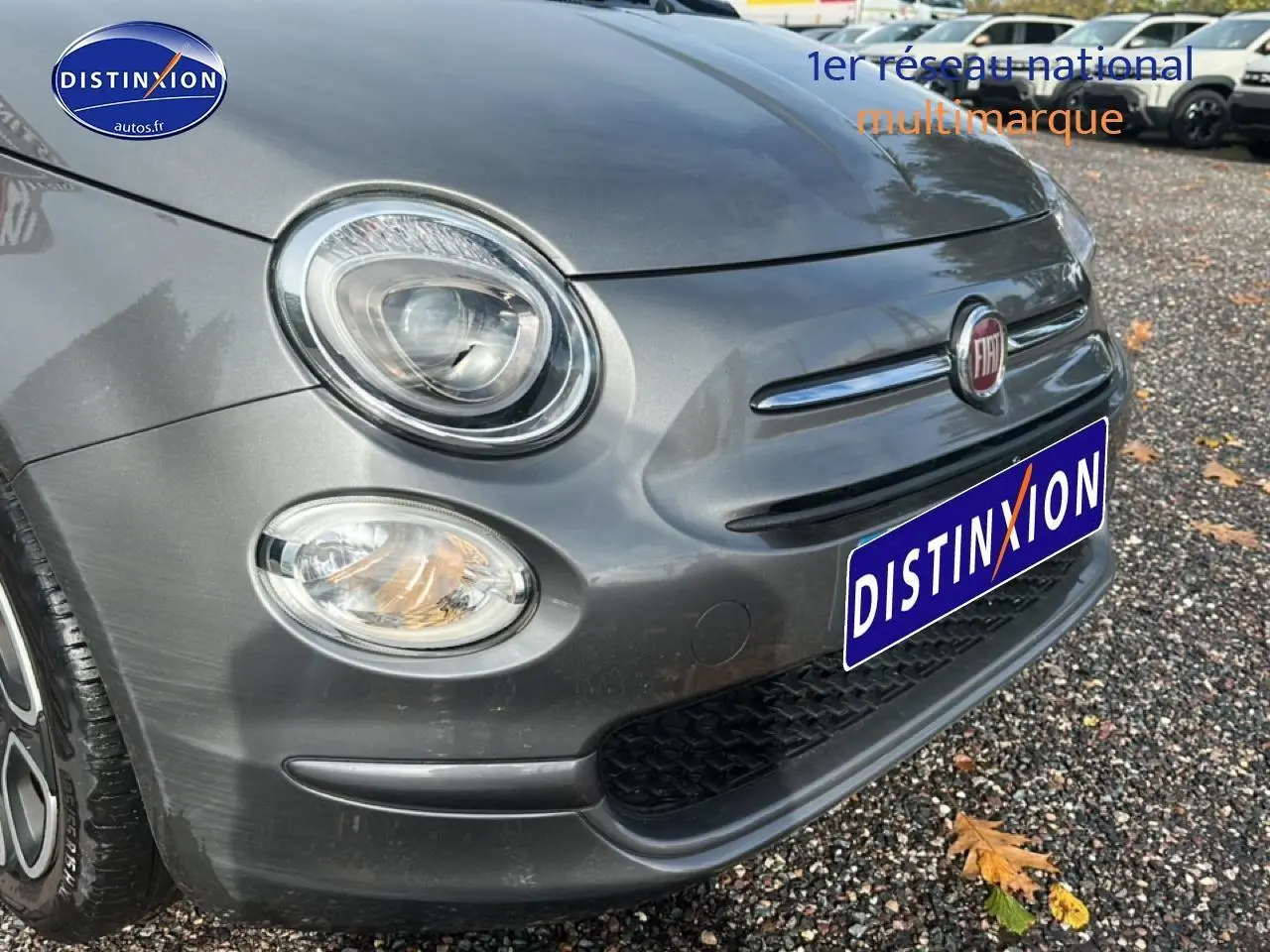 Vue 3/4 avant gauche d'une FIAT 500 gris métallisé avec phares ronds et calandre chromée.