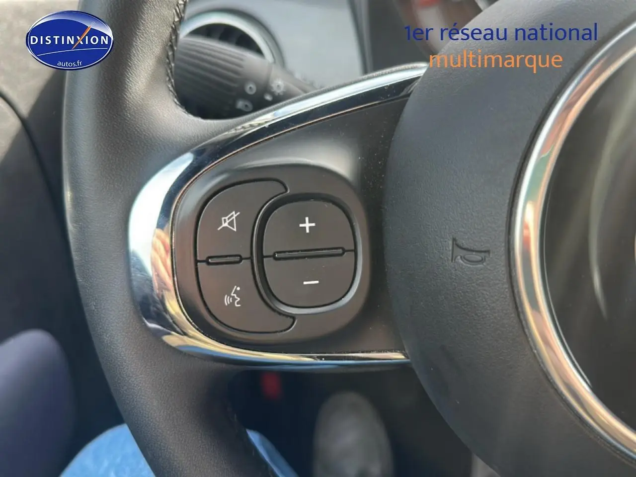 Gros plan sur les commandes audio au volant côté gauche d'une Fiat 500 gris 2022, avec finition chromée.
