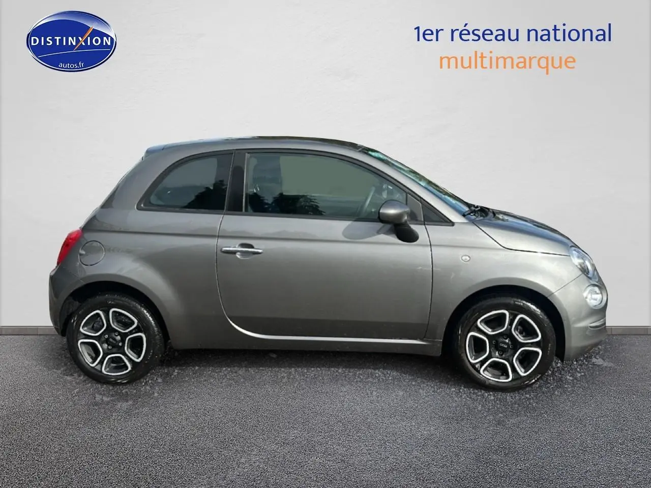 Profil droit d'une Fiat 500 gris métallisé de 2022 avec jantes alliage et poignées de porte chromées.