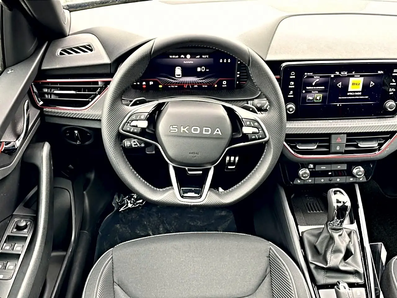 Vue intérieure frontale du poste de conduite noir du Skoda Kamiq 2026 avec volant multifonction et écran tactile central.