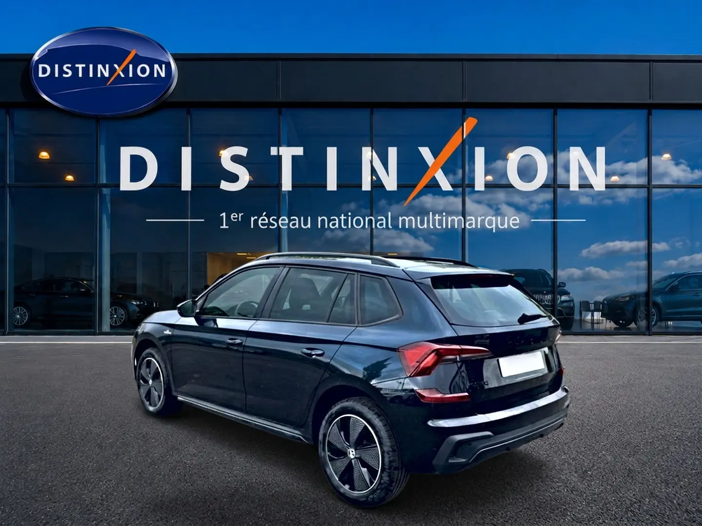 Vue 3/4 arrière droite d'un Skoda Kamiq noir avec jantes alu, garé devant une vitrine Distinxion.