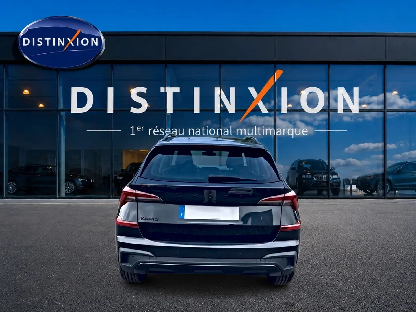 Vue arrière d'un Skoda Kamiq noir 2026 garé devant une vitrine avec logo Distinxion.