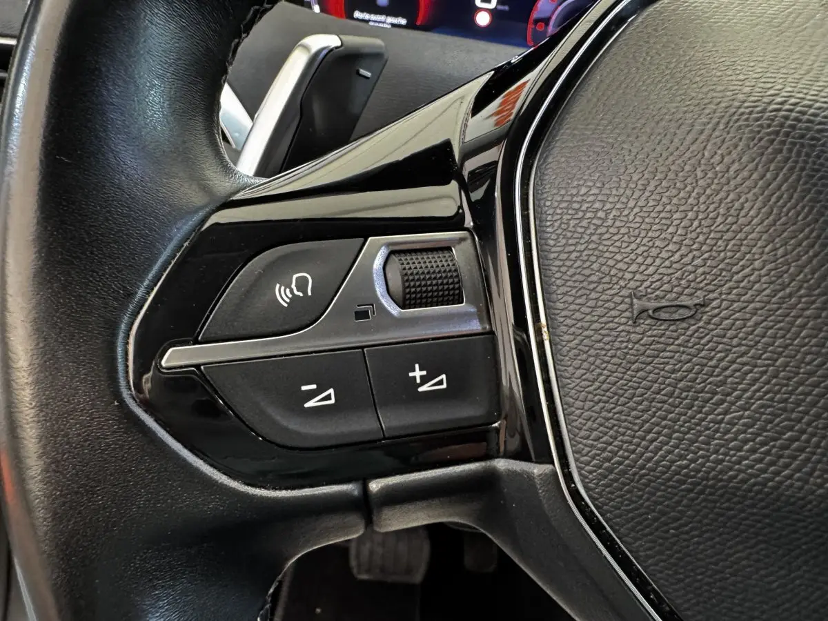 Gros plan sur les commandes vocales et volume du volant cuir noir du Peugeot 5008 2022 BlueHDi.