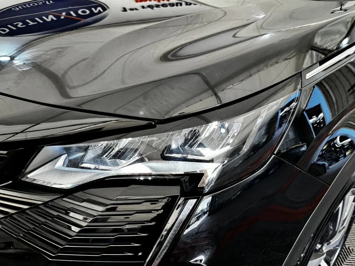 Gros plan sur le phare avant droit du Peugeot 5008 noir 2022, soulignant ses lignes modernes et détails LED.