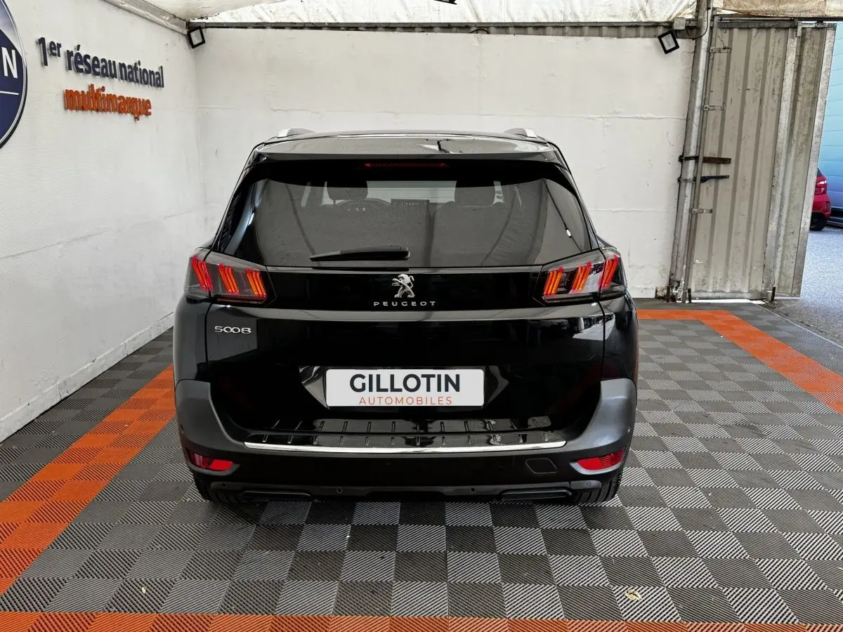 Vue arrière d'un Peugeot 5008 noir 2022, avec feux LED distinctifs et logo lion centré sur le hayon.