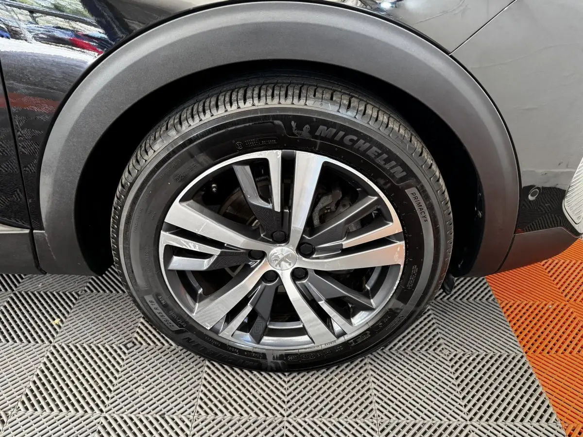 Gros plan sur la roue avant droite noire du Peugeot 5008 2022 avec jante alliage et pneu Michelin.