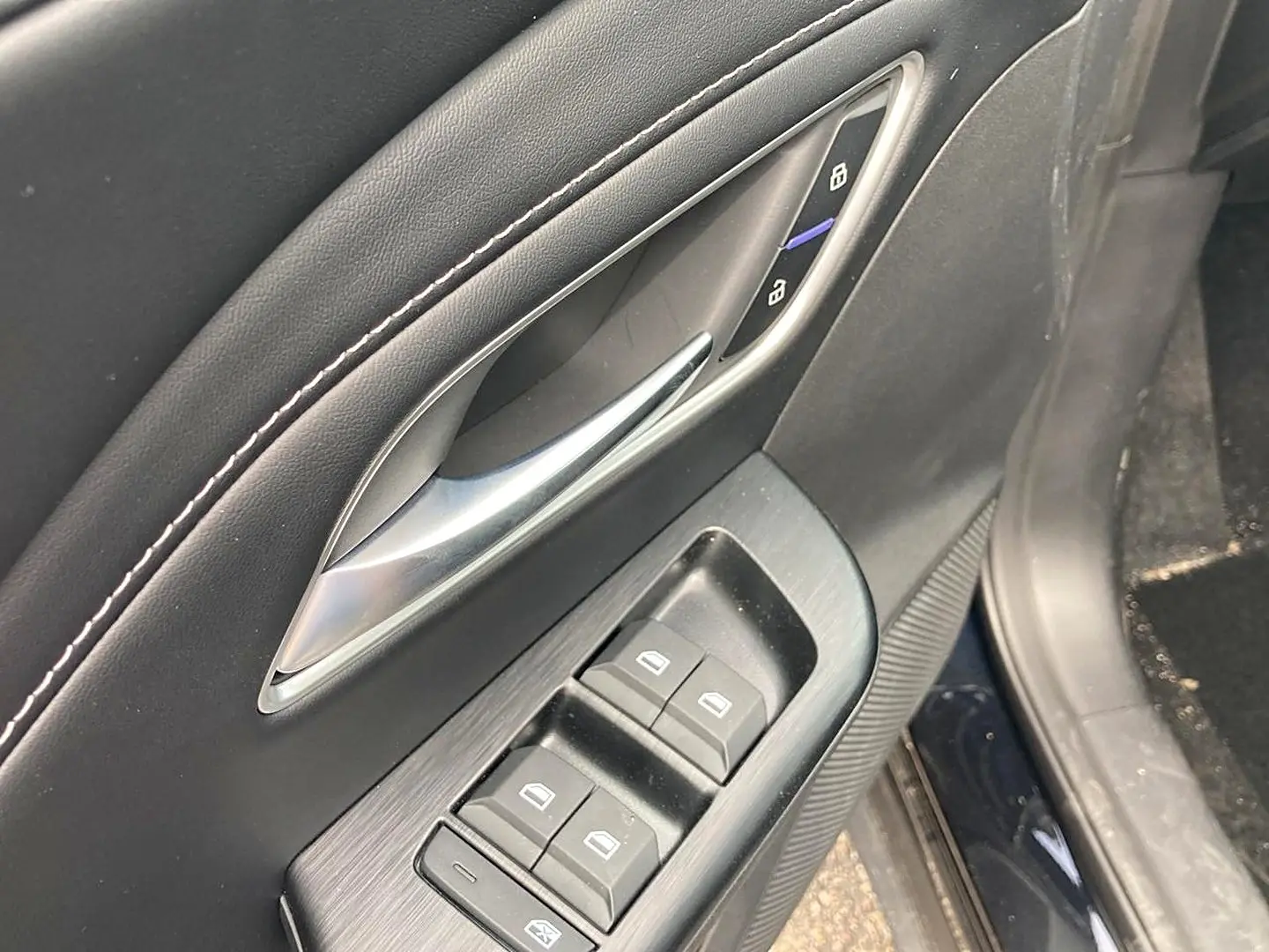 Détail de la porte avant gauche noire du MG ZS 1.5 hybrid 197 luxury avec commandes de vitres et verrouillage.