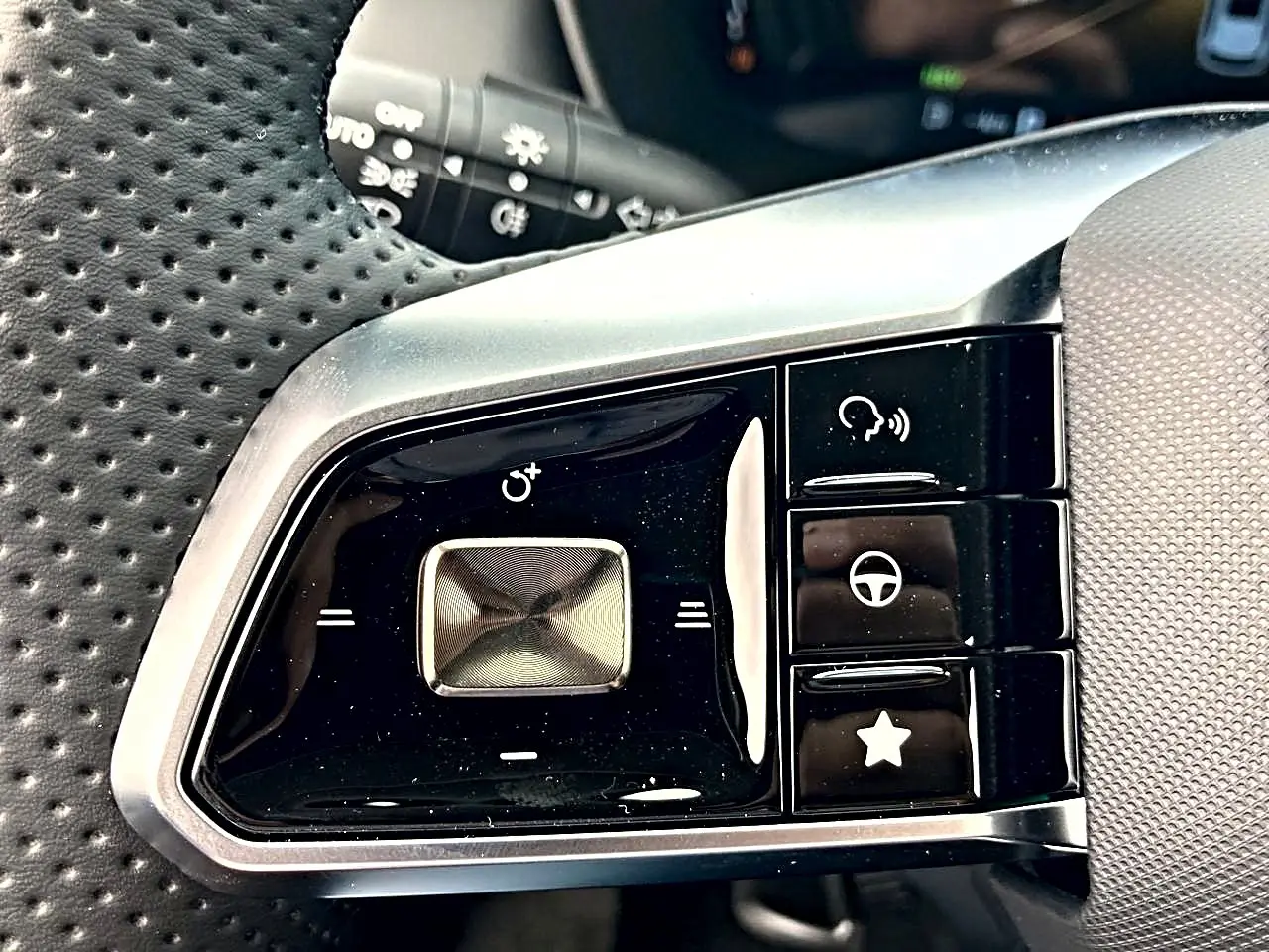 Gros plan sur les commandes noires et argentées du volant multifonction perforé côté gauche du MG ZS 1.5 hybrid 197 luxury noir.