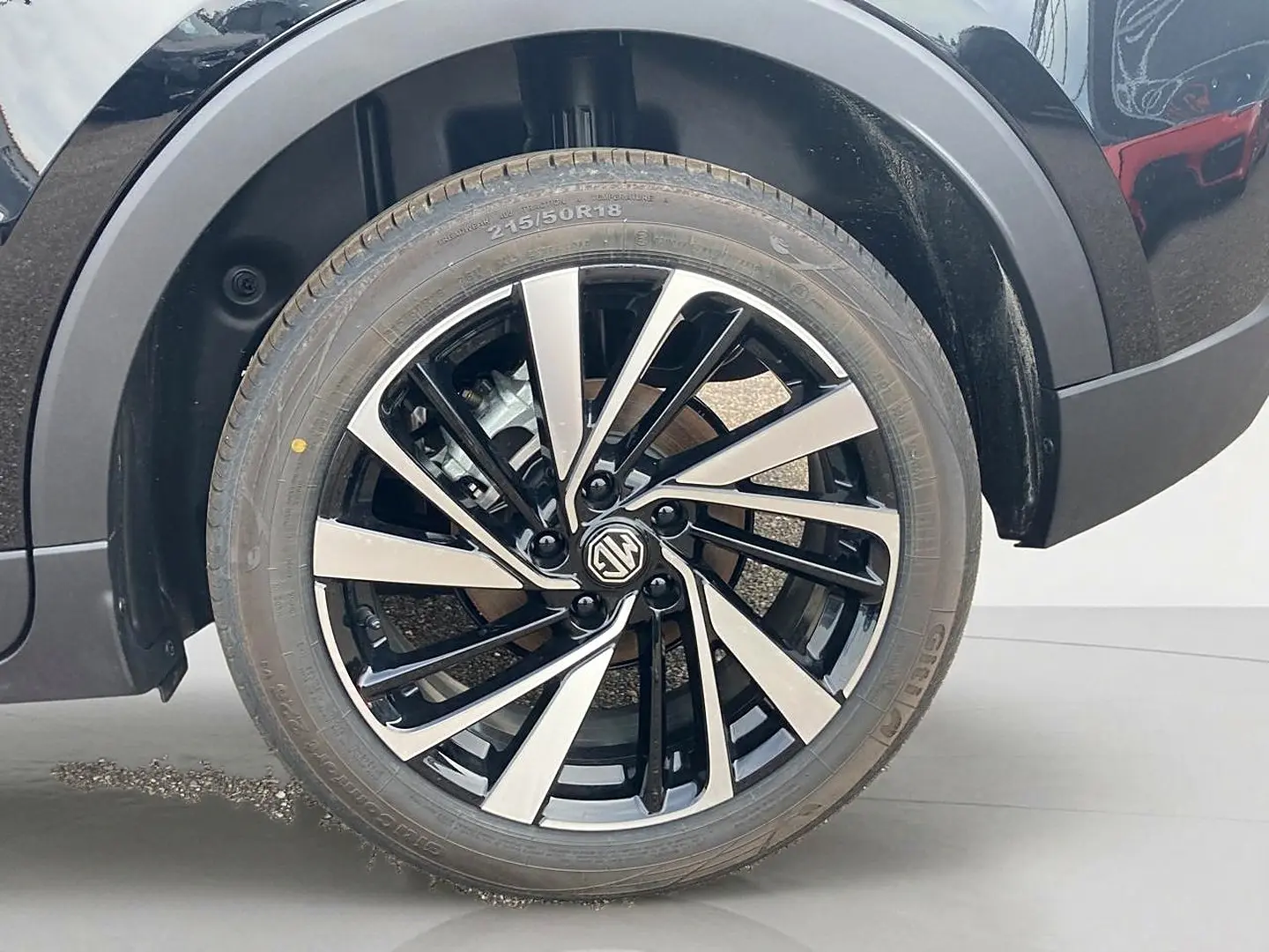 Gros plan sur la roue avant droite noire avec jante alu bicolore du MG Motor ZS 1.5 hybrid 197 luxury 2026.