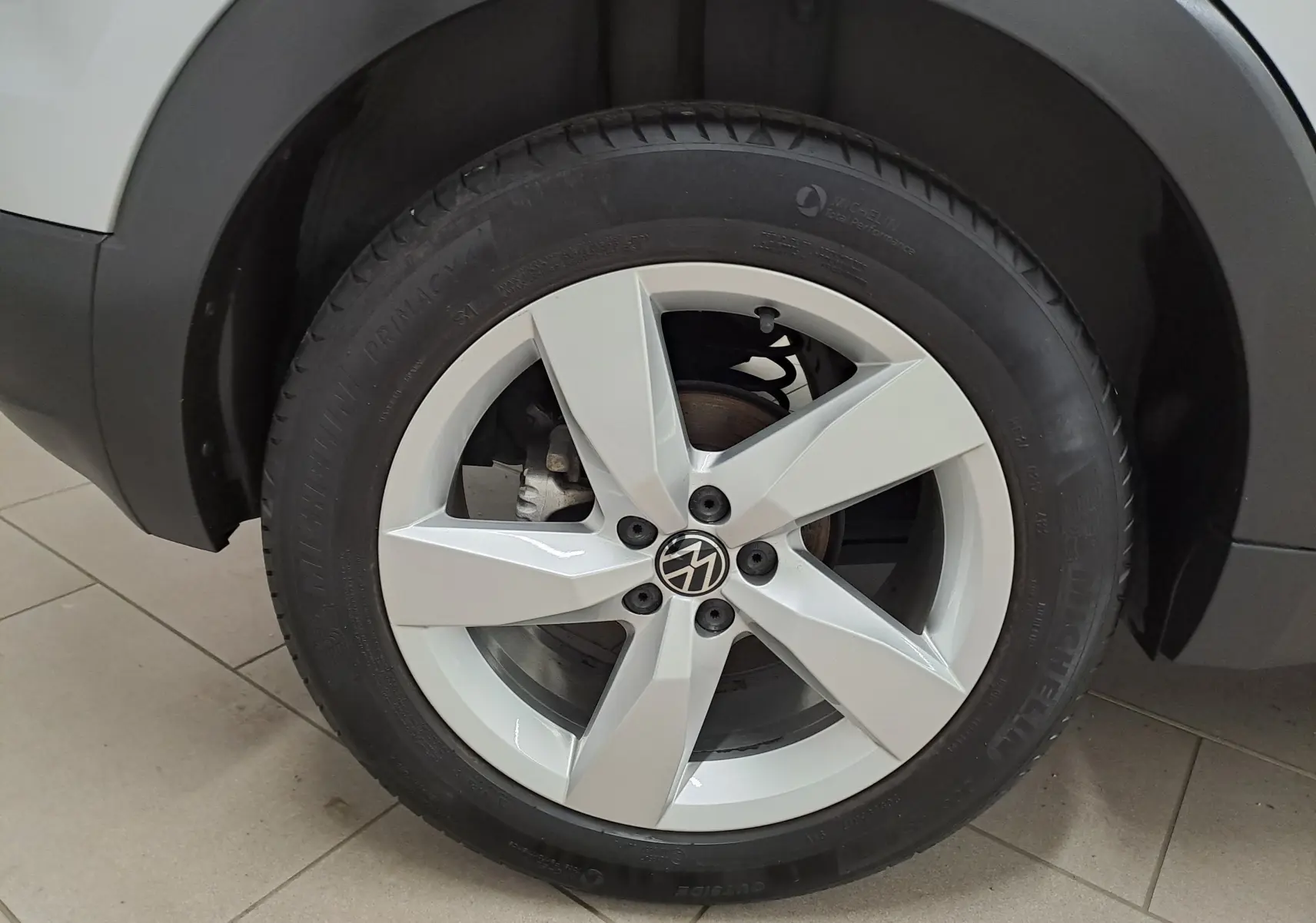 Gros plan sur la roue avant droite du Volkswagen T-Cross 2022 en peinture métallisée Reflet d'argent avec jante cinq branches.