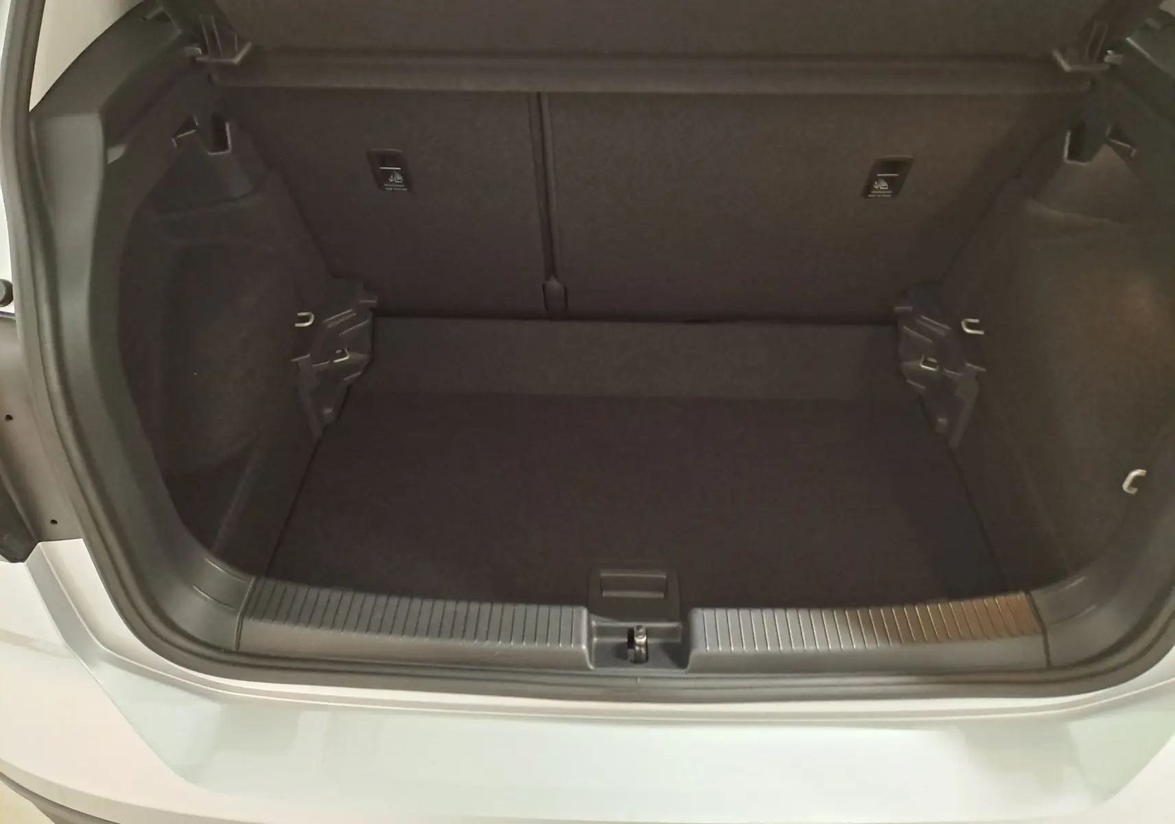 Coffre ouvert vu de l'arrière d'un Volkswagen T-Cross 2022 couleur reflet d'argent, montrant l'espace de chargement vide.