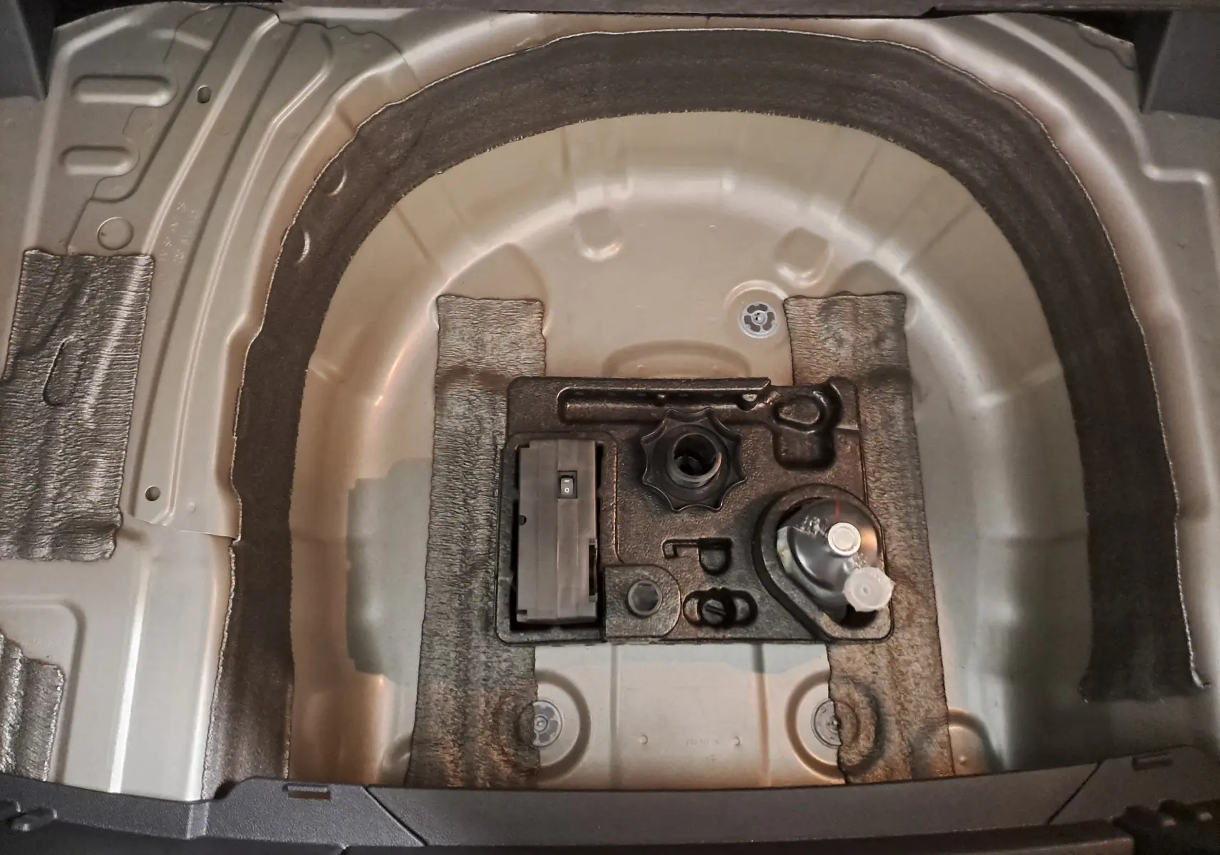 Vue rapprochée de la zone de rangement sous le coffre du Volkswagen T-Cross 2022, sans roue de secours visible.