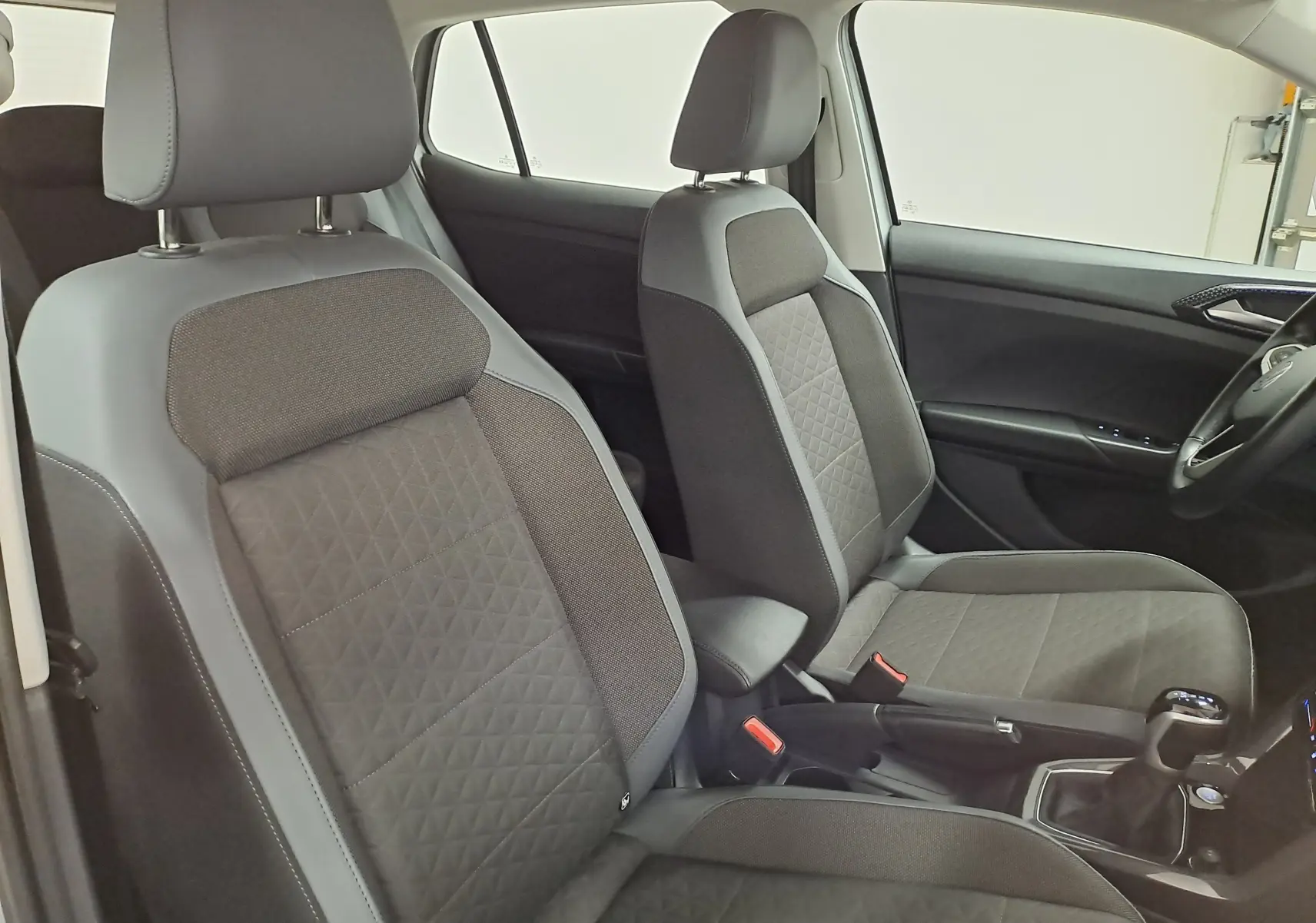 Vue intérieure des sièges avant gris foncé avec surpiqûres en losange du Volkswagen T-Cross 2022 côté conducteur.