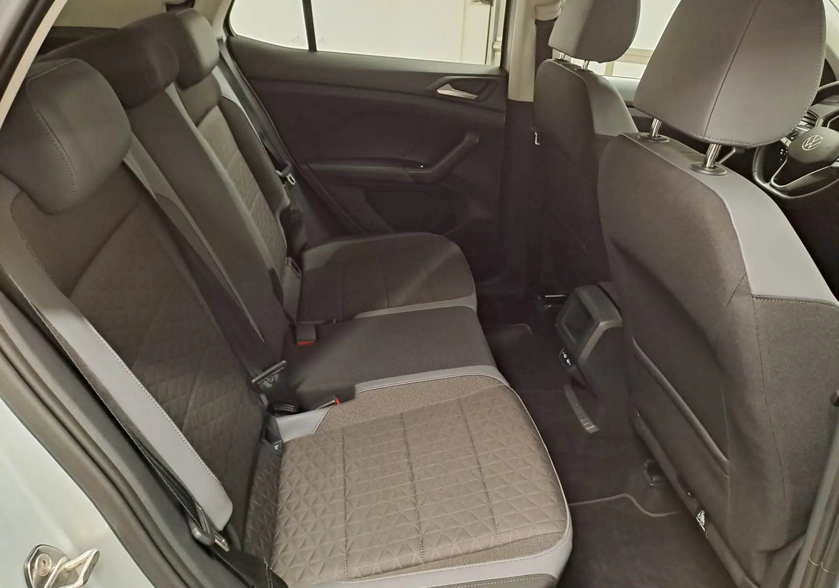 Intérieur arrière du Volkswagen T-Cross 2022, vue côté gauche, sièges tissu gris avec motifs géométriques.