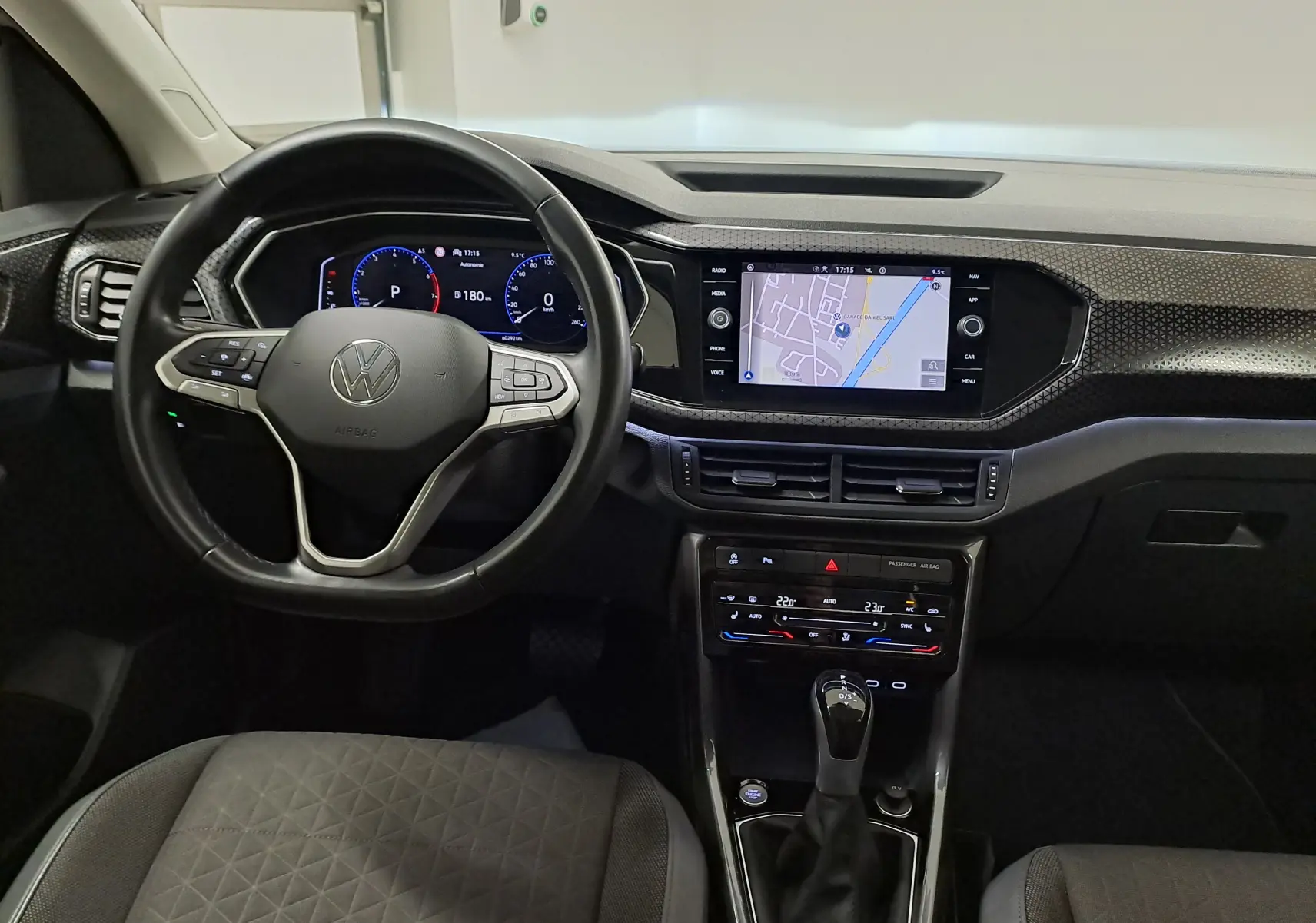 Vue intérieure du tableau de bord du Volkswagen T-Cross 2022, avec volant multifonction et écran tactile de navigation.