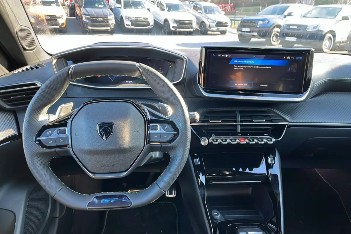 Vue intérieure frontale du tableau de bord noir et volant GT du Peugeot 2008 Hybrid 145 E-DSC6 GT Vision 2025.