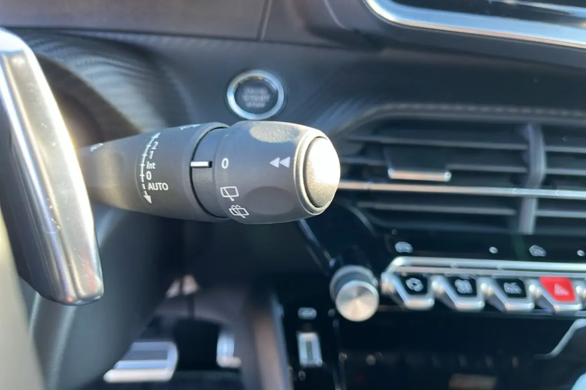 Gros plan sur la commande d’essuie-glace du tableau de bord noir du Peugeot 2008 Hybrid 145 GT Vision 2025.