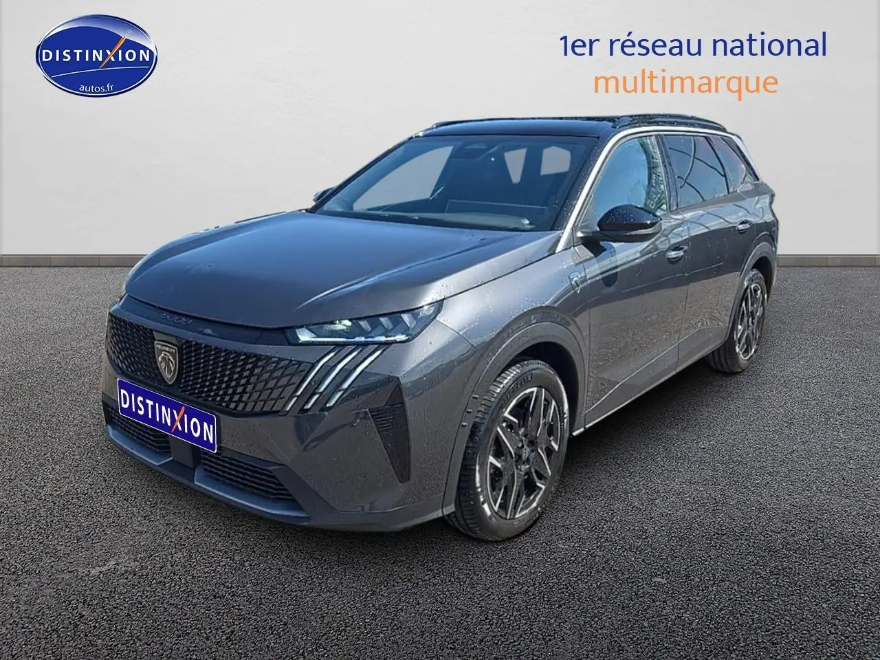 Vue 3/4 avant d’un Peugeot 5008 Hybrid gris titane avec jantes alu et calandre distinctive moderne.