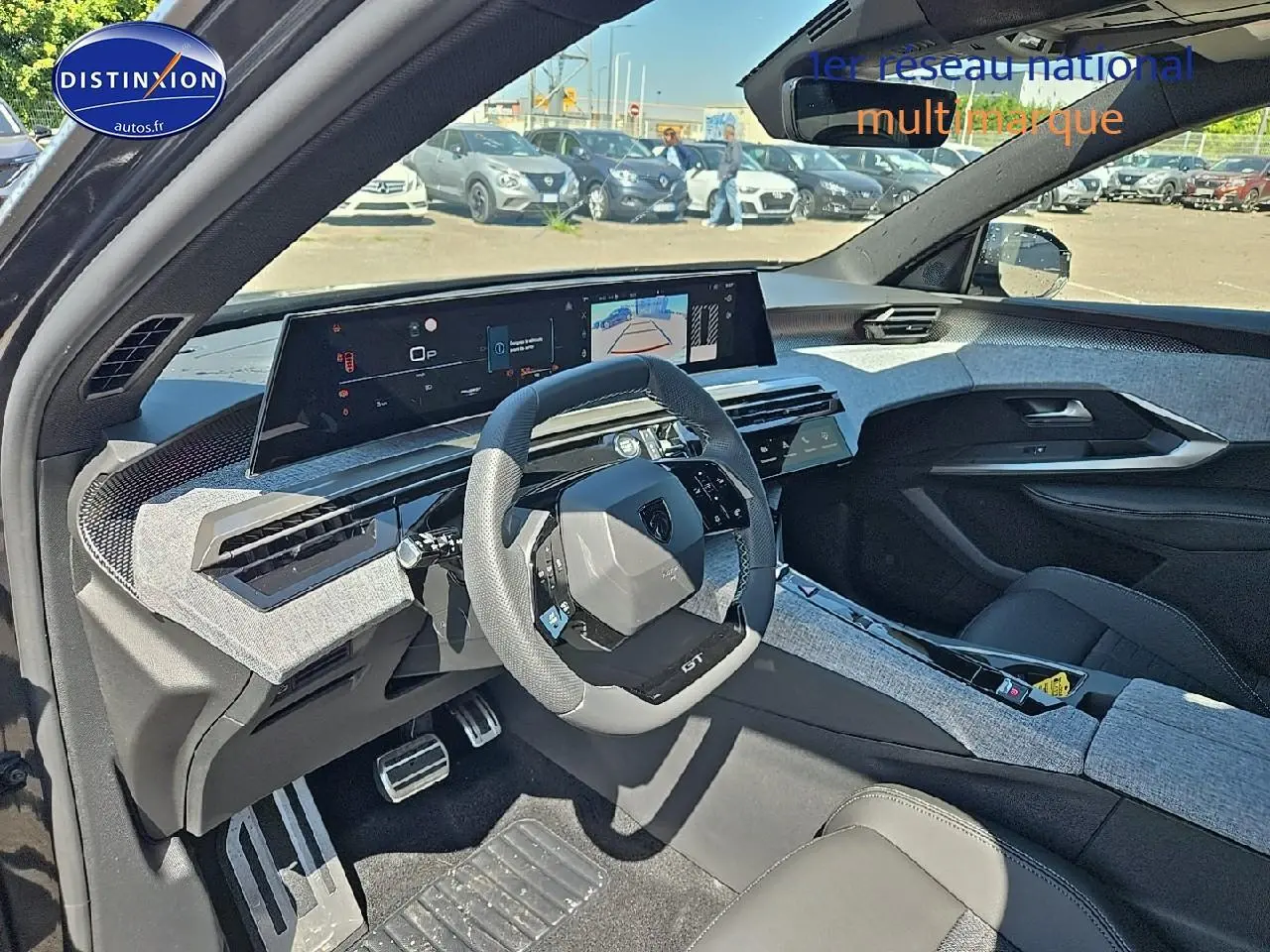 Vue intérieure côté conducteur du Peugeot 5008 Hybrid gris titane, avec tableau de bord numérique et volant multifonction.
