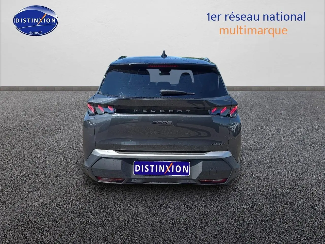 Vue arrière d’un Peugeot 5008 Hybrid gris titane avec feux LED caractéristiques et hayon électrique fermé.