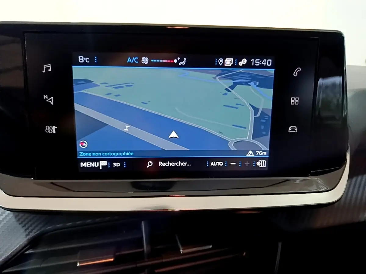 Écran tactile central de navigation de la Peugeot 208 blanc, affichant une carte et les réglages climatisation.